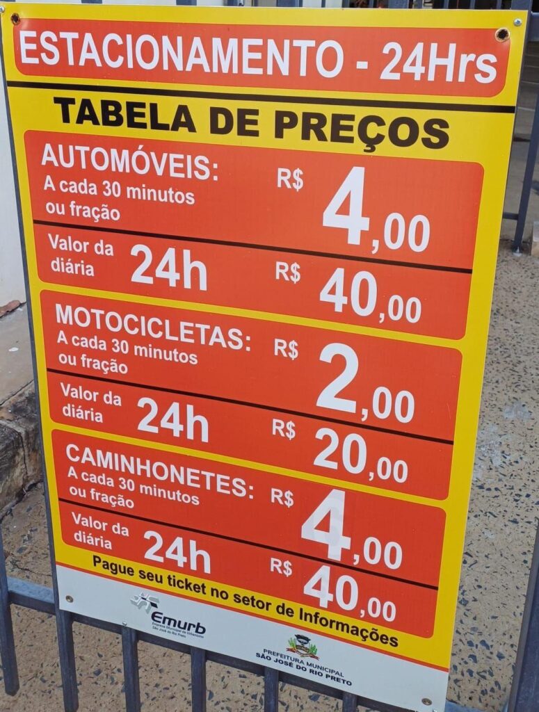 Avisos em tabela de preço para estacionamento.